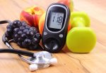 Glucose meter with medical stethoscope, fruits and dumbbells for using in fitness, concept of diabetes, healthy lifestyles and nutrition.