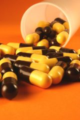 orange and brown capsules spilling out of a cup