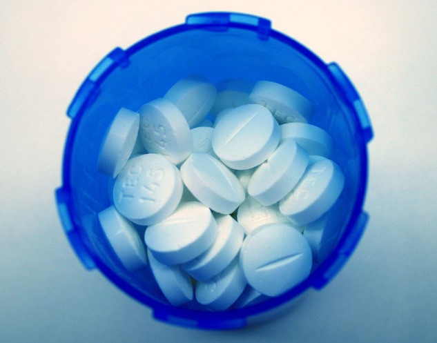 white pills in a blue cup