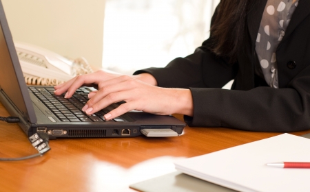 Close up of a woman hands typing on laptop.