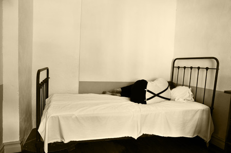 Depressed man on bed in a mental hospital.