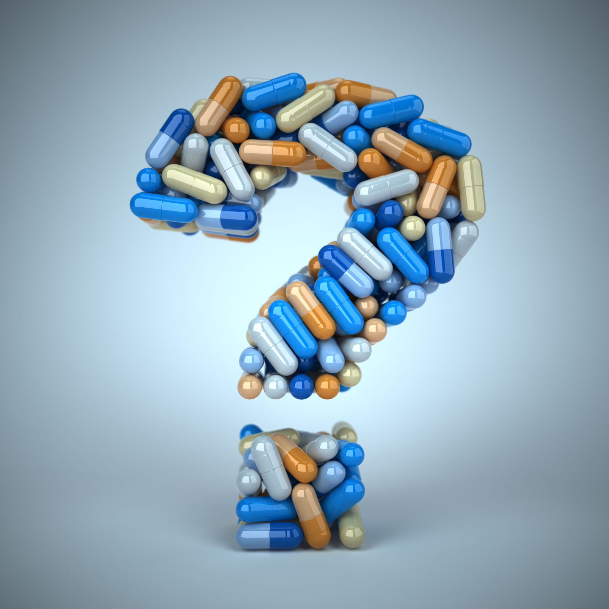 Pills or capsules as a question mark on a blue background.