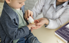 Young boy being given pills